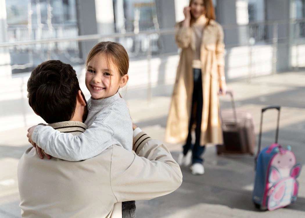 Father hugging his daughter at an airport during a family separation moment