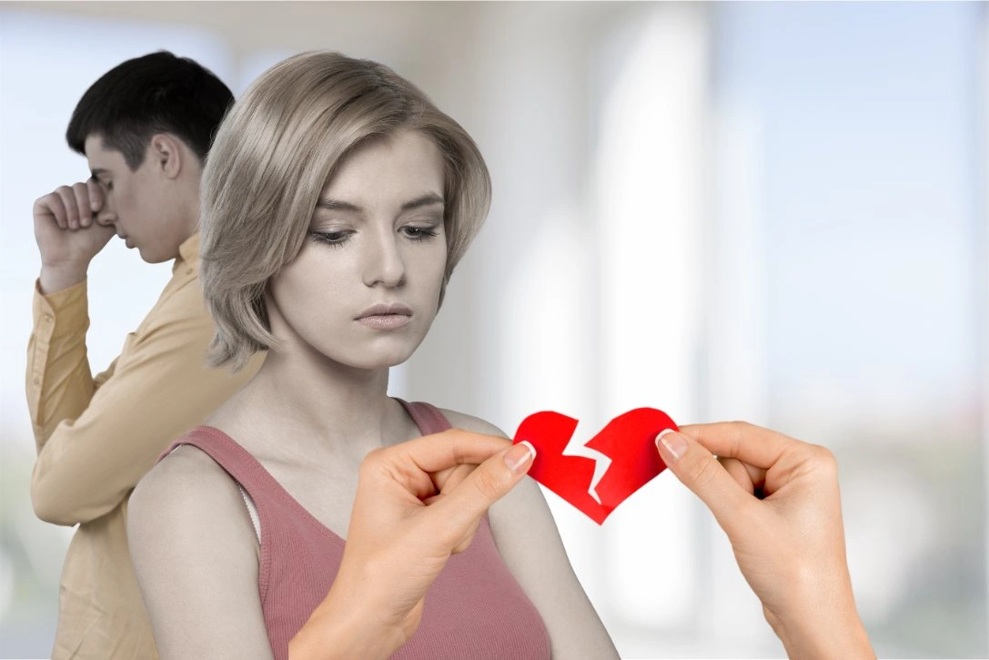 Sad couple with broken heart symbol representing de facto relationship breakdown and separation.