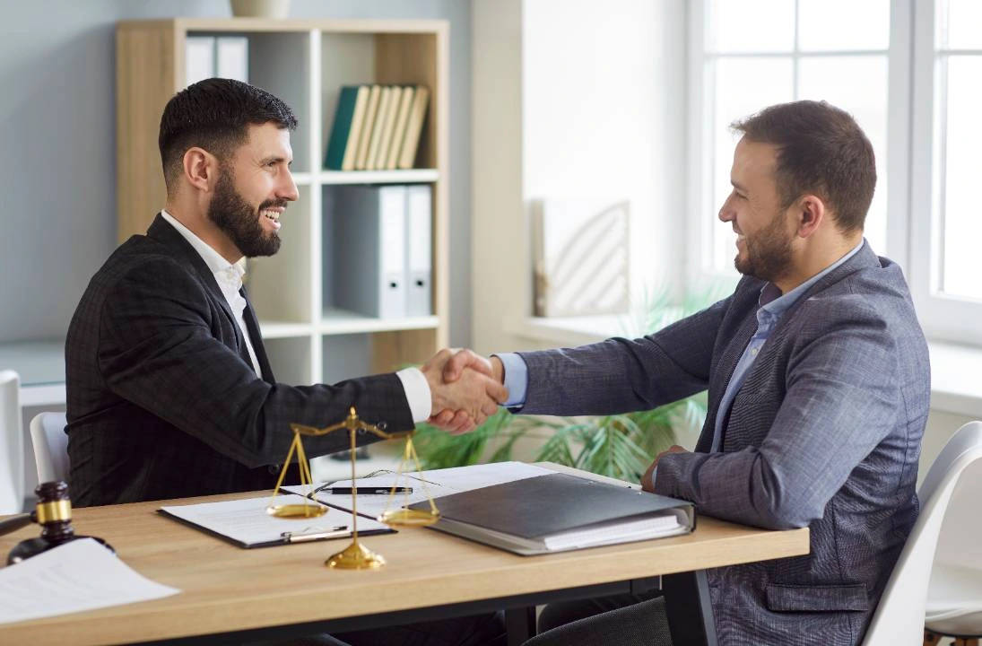 Lawyer and client shaking hands after reaching a family law agreement.